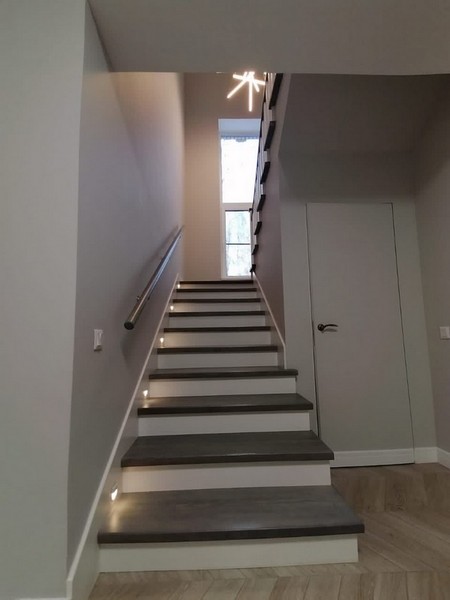 Отделка бетонной лестницы цельноламельными ступенями из ясеня и мдф с буковыми балясинами со светильниками в стене с Салтыковке