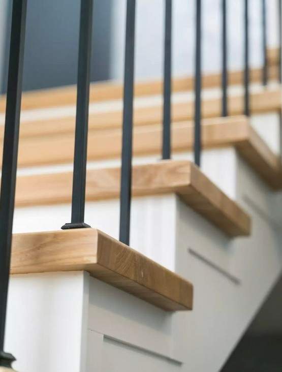 Отделка бетонной лестницы паркетными ступенями из ясеня и мдф с металлическими балясинами в Кубинке