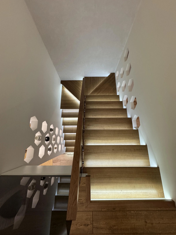 Лестница на бетонной основе с цельноламельным ясенем, стеклом и подсветкой, частный дом