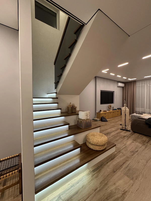 Лестница на бетонной основе с цельноламельным ясенем, стеклом и подсветкой, частный дом