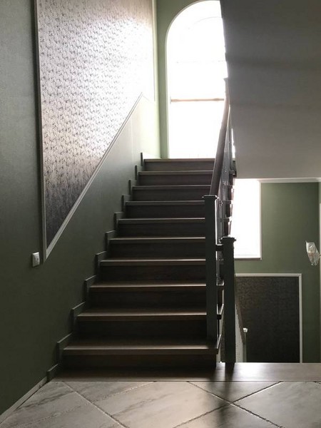Отделка бетонной лестницы цельноламельными ступенями из ясеня с металлическими балясинами в Подольске