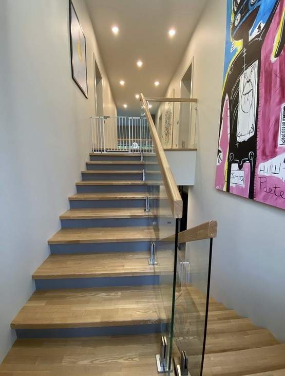 Отделка бетонной лестницы паркетными ступенями из ясеня со стеклянным ограждением в КИЗ 