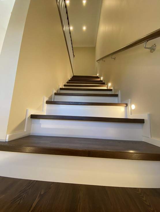 Отделка бетонной лестницы паркетными ступенями из ясеня и мдф со светильниками в стене в Видном