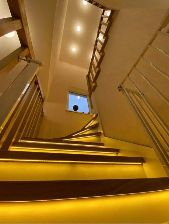 Отделка бетонной лестницы комбинацией цельноламельных ступеней из ясеня и мдф с балясинами из ясеня с подсветкой в Троице-Сельцо