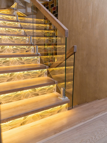 Лестница на металлическом монокосоуре с паркетными ступенями из ясеня с подсветкой и стеклянным ограждением
