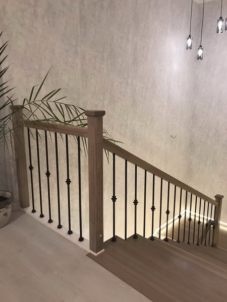 Отделка бетонной лестницы цельноламельными ступенями из ясеня и мдф с металлическими балясинами с горизонтальной подсветкой в Троицком
