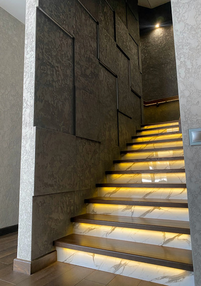 Лестница на закрытом металлическом каркасе вокруг лифта со стеклом и каменными подступенниками 1