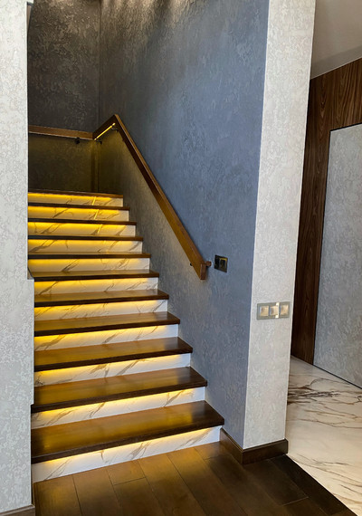 Лестница на закрытом металлическом каркасе вокруг лифта со стеклом и каменными подступенниками 2