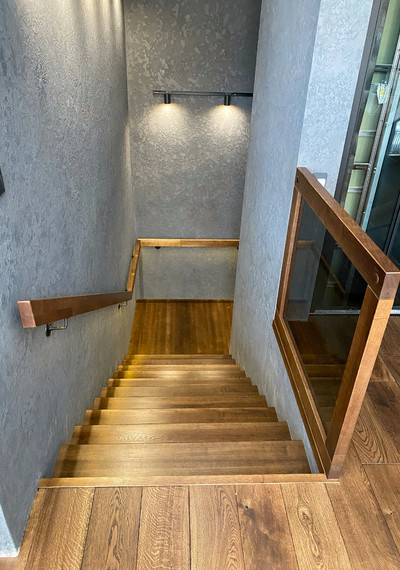 Лестница на закрытом металлическом каркасе вокруг лифта со стеклом и каменными подступенниками 4