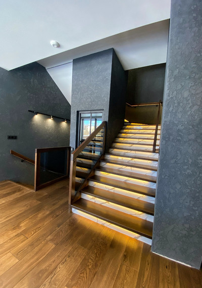 Лестница на закрытом металлическом каркасе вокруг лифта со стеклом и каменными подступенниками 6