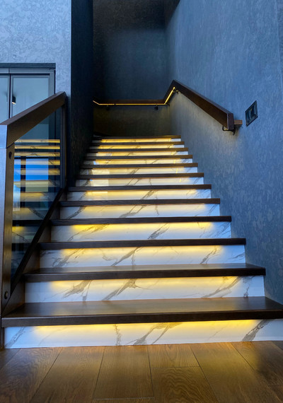 Лестница на закрытом металлическом каркасе вокруг лифта со стеклом и каменными подступенниками 8