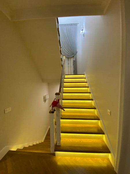 Металлическая лестница закрытого типа с облицовкой дубом и МДФ и комбинированным ограждением с подсветкой