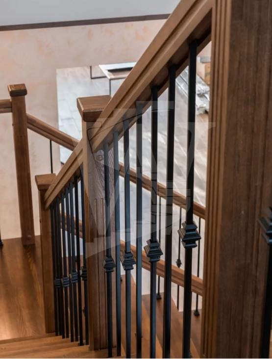 Отделка бетонной лестницы цельноламельными ступенями из ясеня и мдф с металлическими балясинами в Клину
