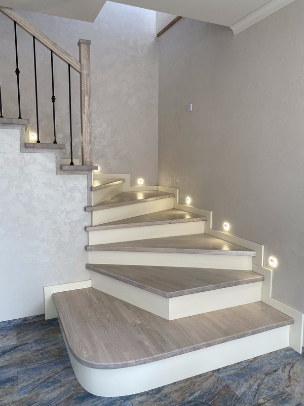 Отделка бетонной лестницы комбинацией паркетных ступеней из ясеня и мдф с ясеневыми столбами и металлическими балясинами в Королёве